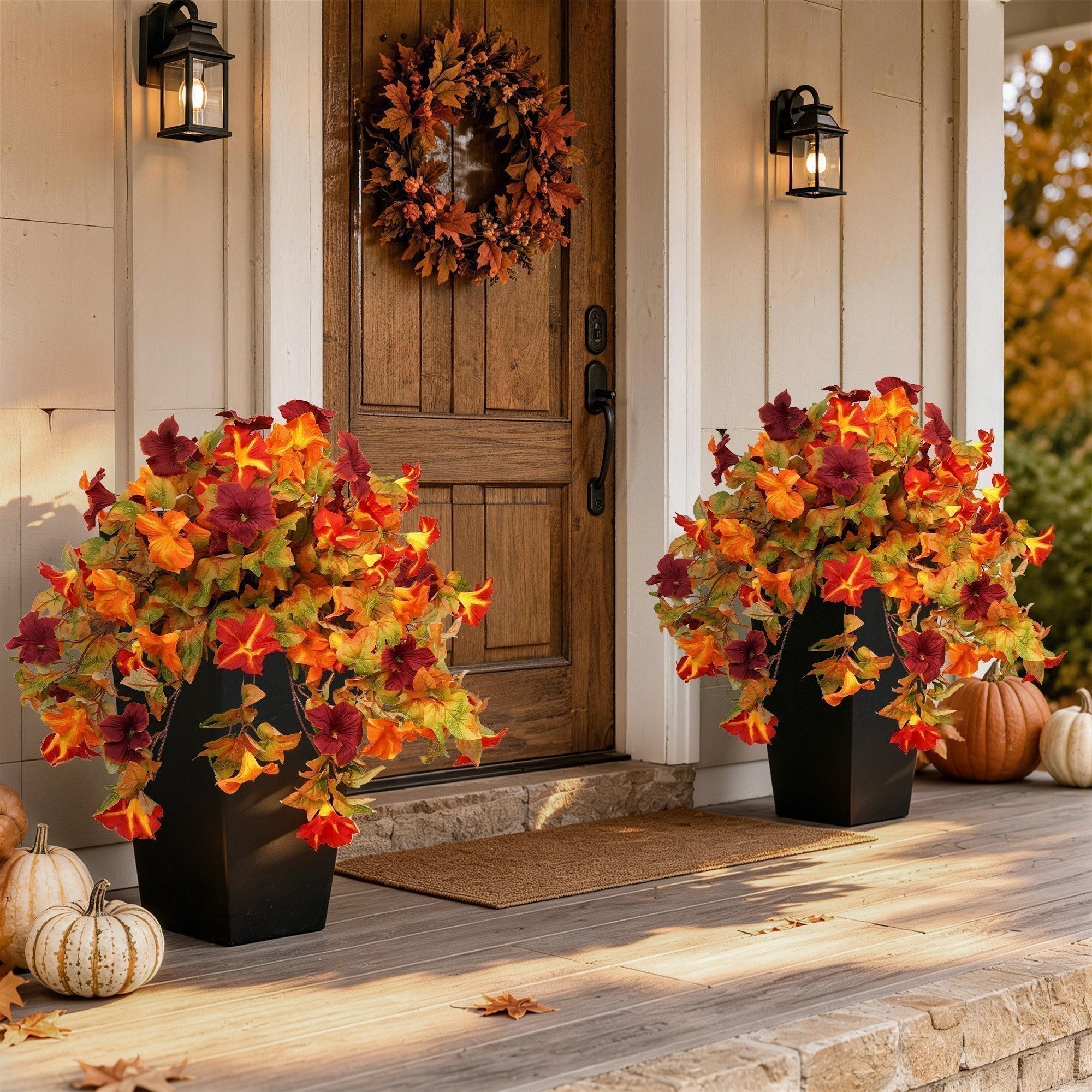 Cozy fall front porch decorated with artificial autumn flowers, harvest wreath and pumpkins