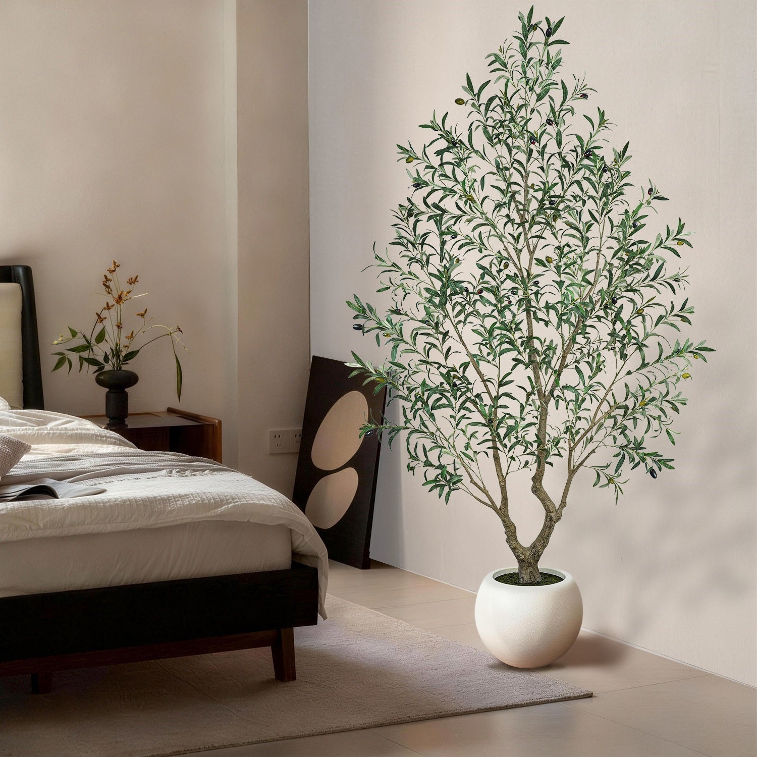 Potted plant in a bedroom setting with a bed and nightstand.