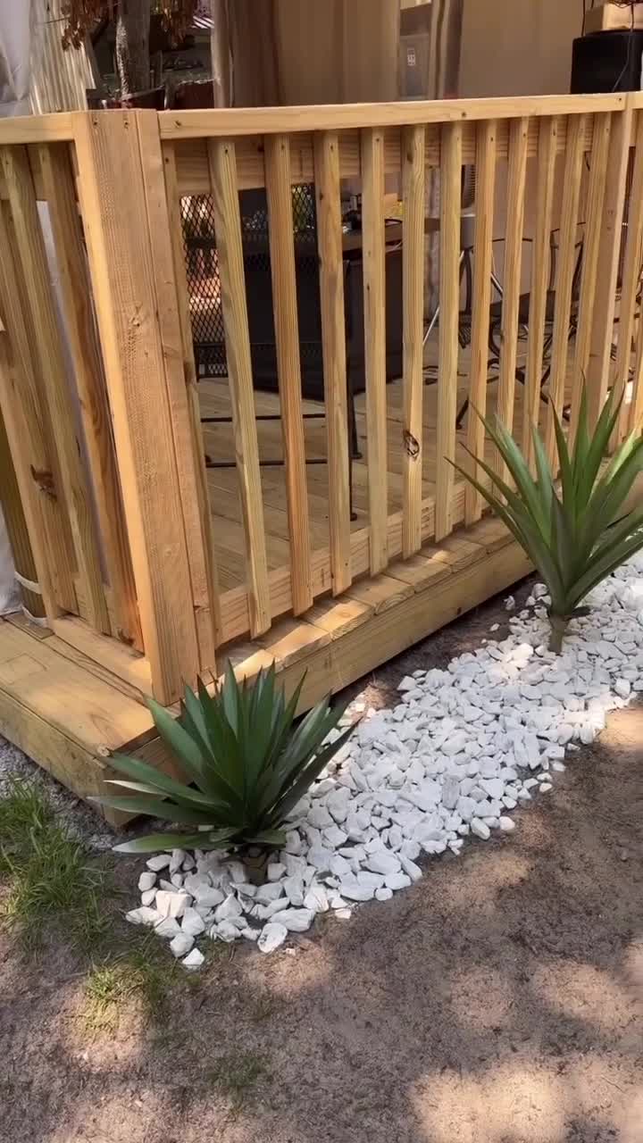 Artificial plants styled beside a wooden outdoor deck